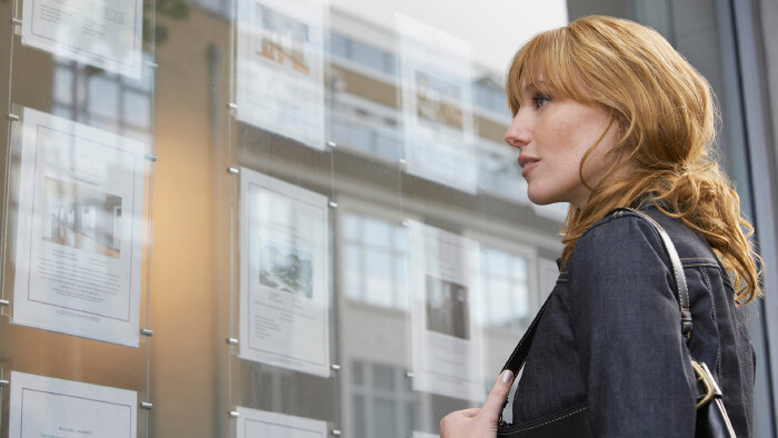 © moodboard, stock.adobe.com Junge Frau liest Wohnungsinserate