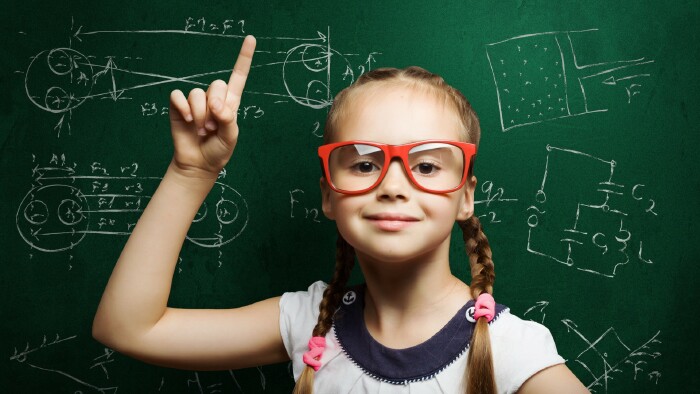 © Sergey Nivens, stock.adobe.com Mädchen mit Zopf und roter Brille an der Tafel